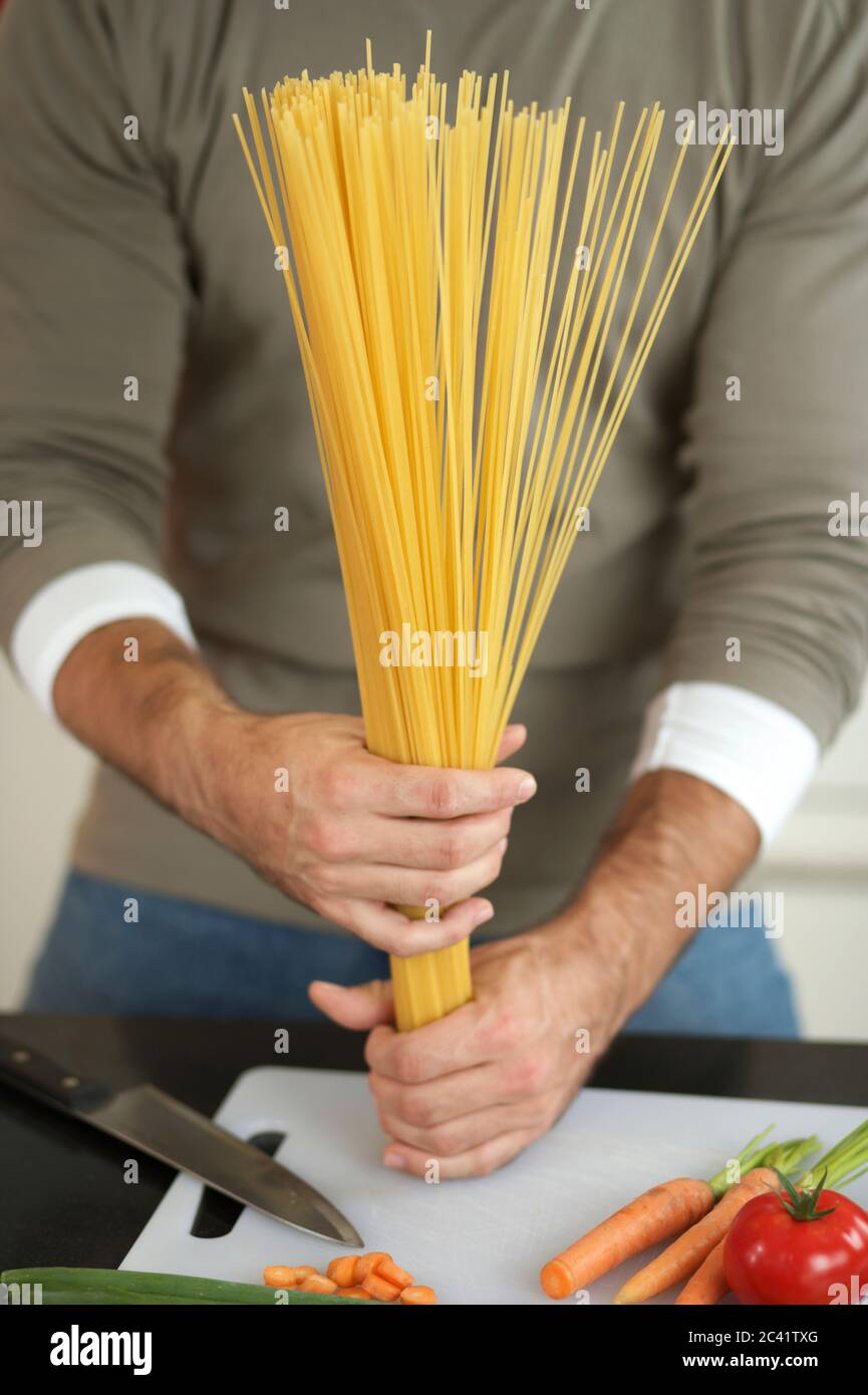 L'uomo tiene gli spaghetti nelle mani Foto Stock