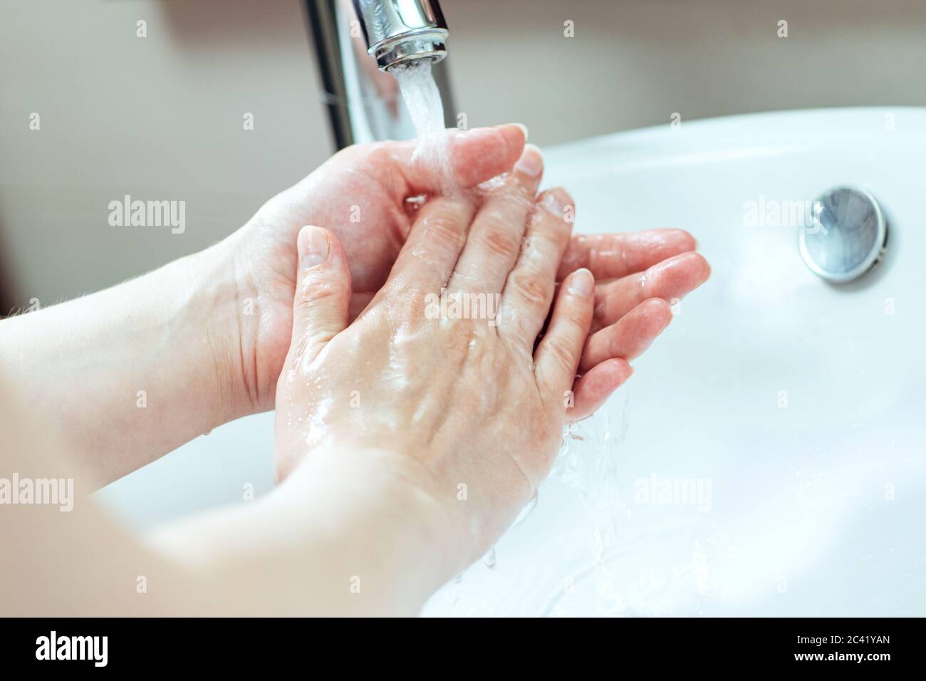 Lavarsi le mani. Le mani femminili vengono lavate nel lavandino Foto Stock