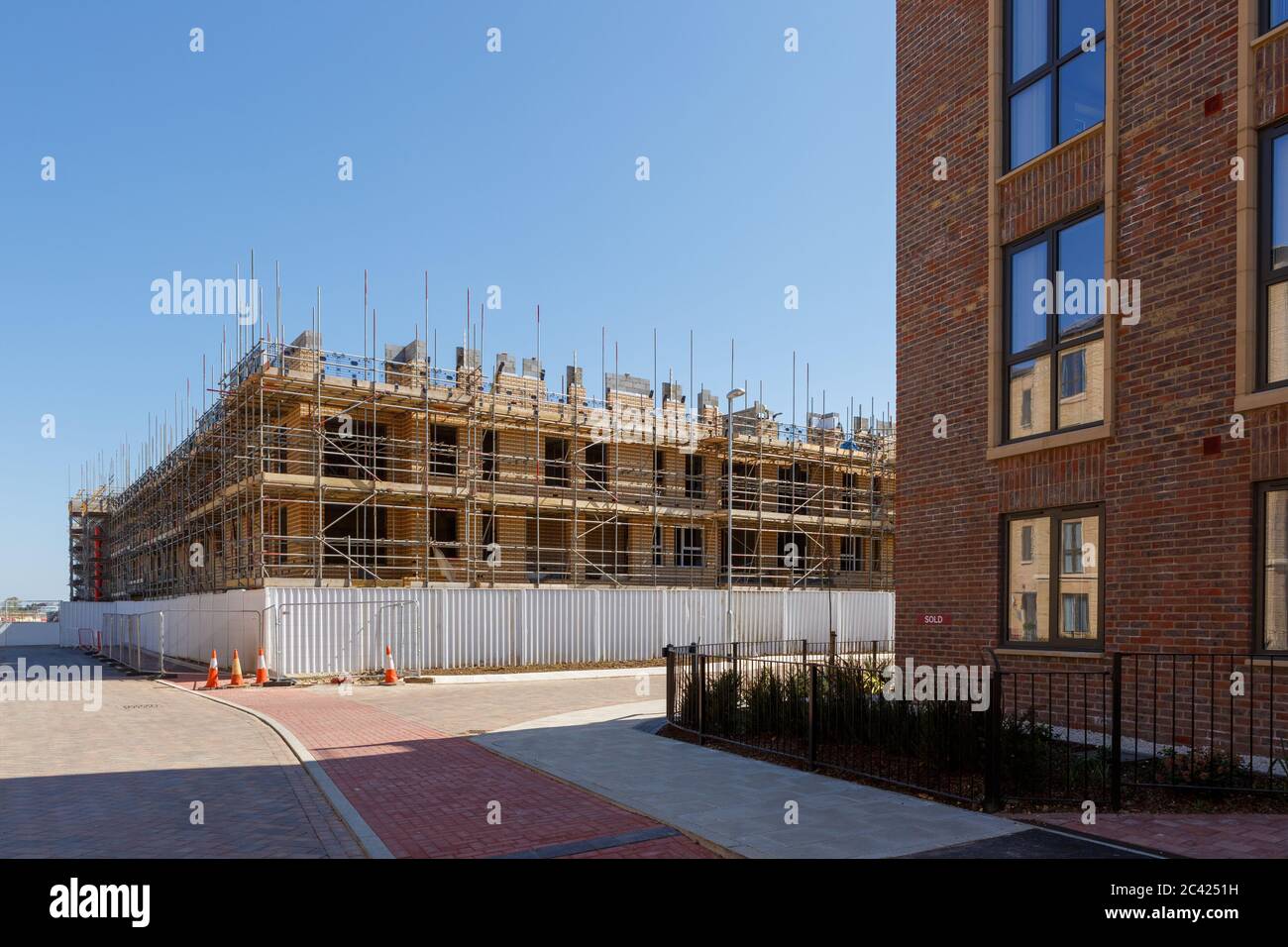 Un cartello venduto è esposto su una nuova casa di costruzione tra i lavori di costruzione a Darwin Green, una nuova comunità a North-West Cambridge. Foto Stock