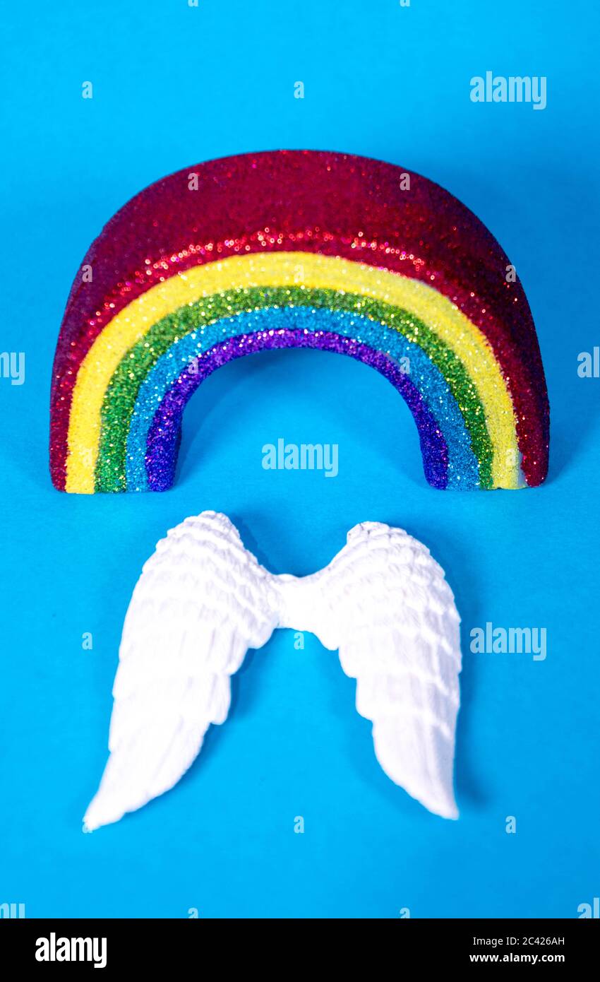 Un set di ali d'angelo bianche con nastro arcobaleno colorato, per ricordare coloro che sono morti. Foto Stock