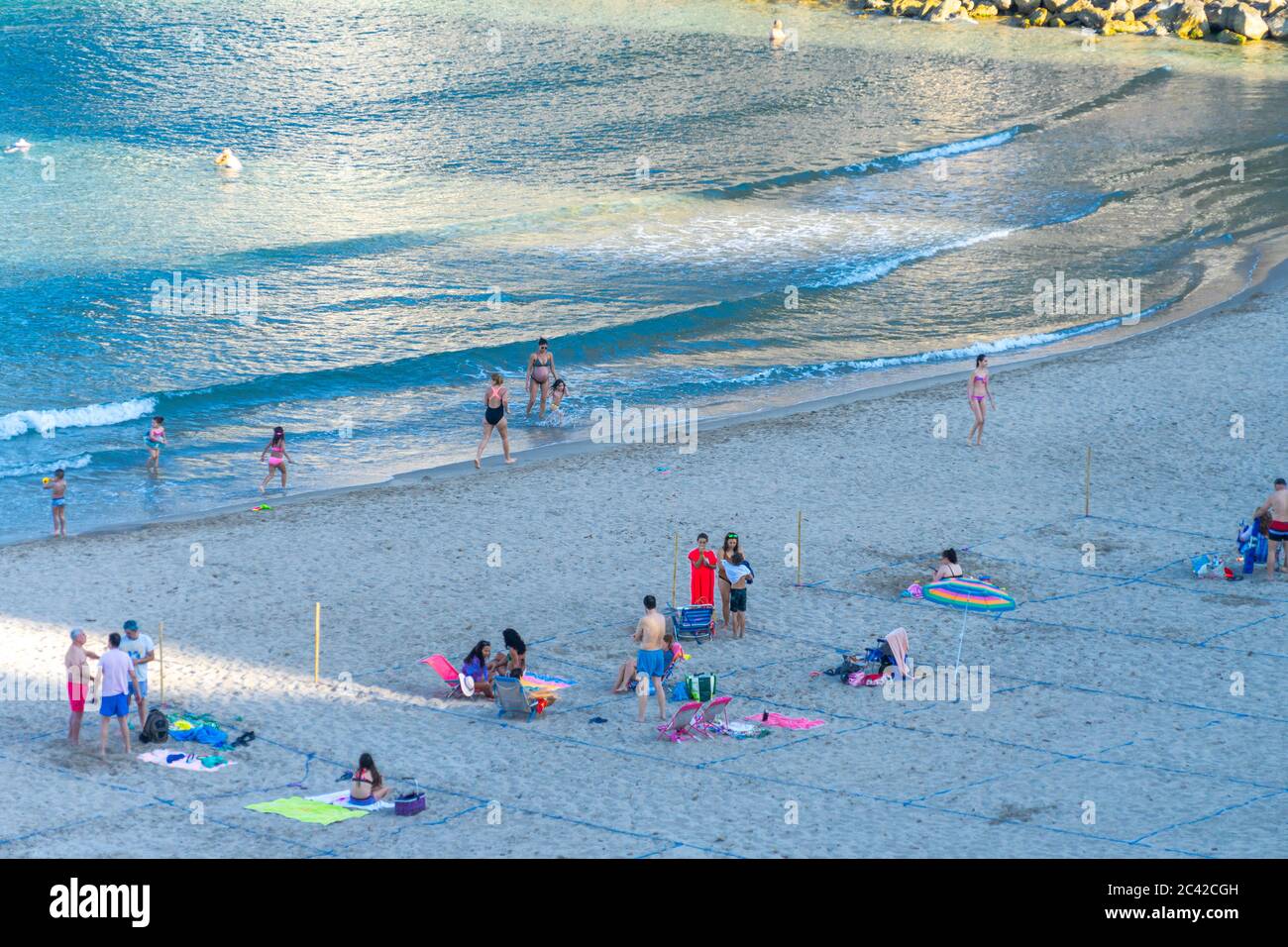 Benidorm, Spagna - 22 giugno 2020: La gente si rilassa nella spiaggia di Poniente divisa in appezzamenti. Popolare resort spagnolo dopo il blocco pandemico di Coronavirus Foto Stock