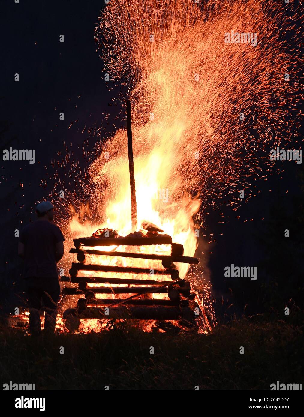Grainau, Germania. 23 Giugno 2020. Un uomo si trova al fuoco di San Giovanni, che si trova alla vigilia del giorno di San Giovanni (24 giugno). Credit: Angelika Warmuth/dpa/Alamy Live News Foto Stock