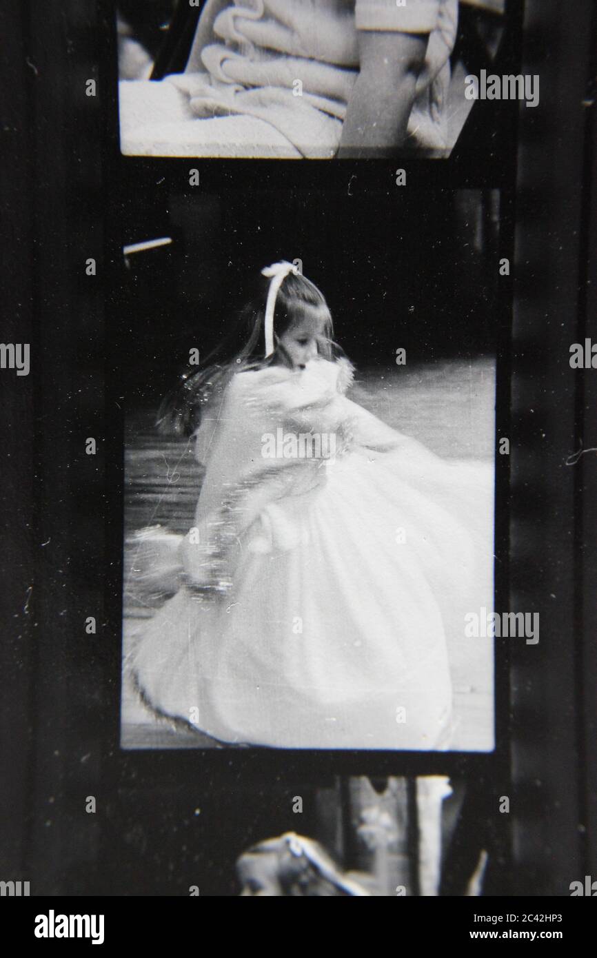 Fine anni '70 vintage contatto stampa in bianco e nero fotografia di una giovane ragazza twirling nel suo vestito bianco. Foto Stock