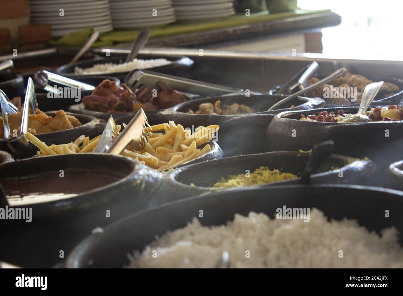 Buffet gratuito in un ristorante self-service, servito su una stufa a legna, con riso, pesce, patatine fritte e farofa Foto Stock