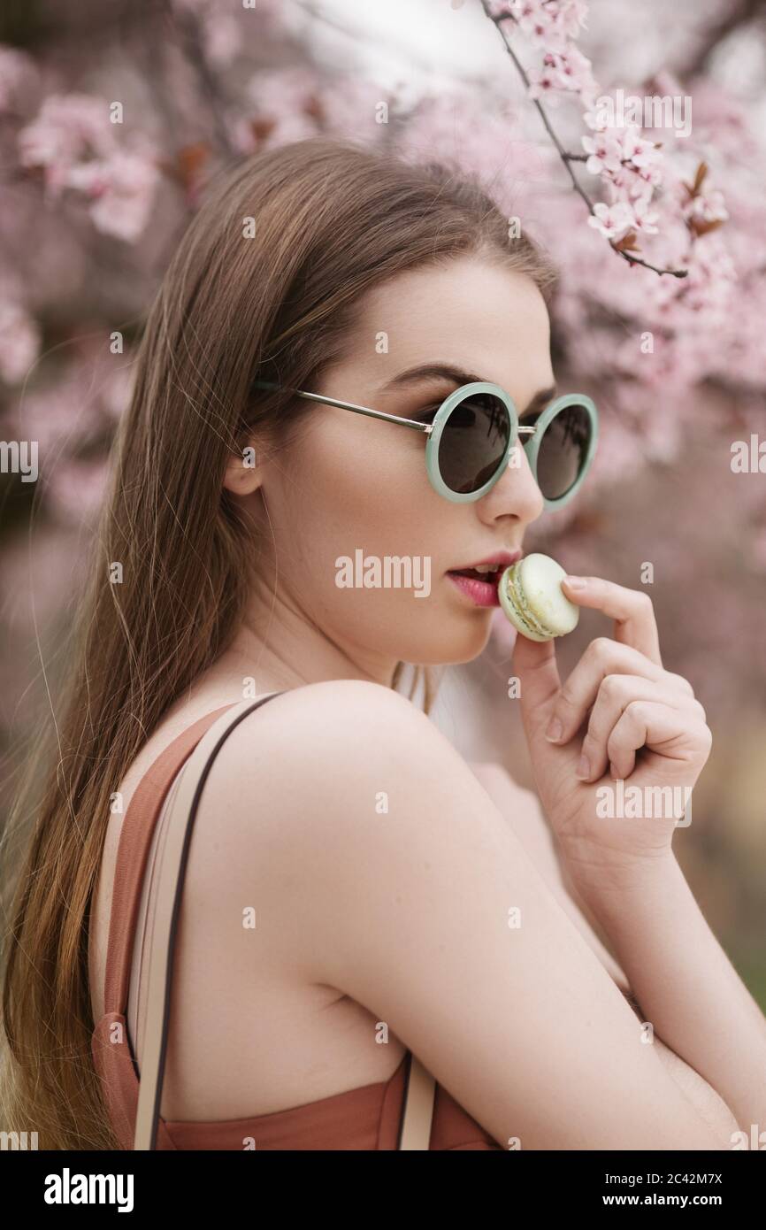 Moda ritratto di una bella ragazza mangiare cookie verde Foto Stock