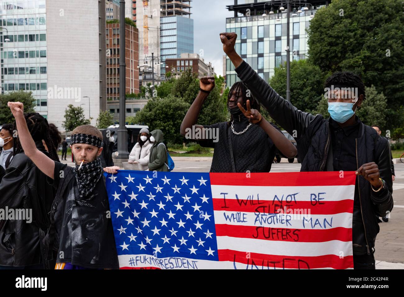 Manifestanti con bandiera americana che sollevano i loro pugni durante l'assemblea di protesta in solidarietà al movimento della materia di Black Lives. Foto Stock