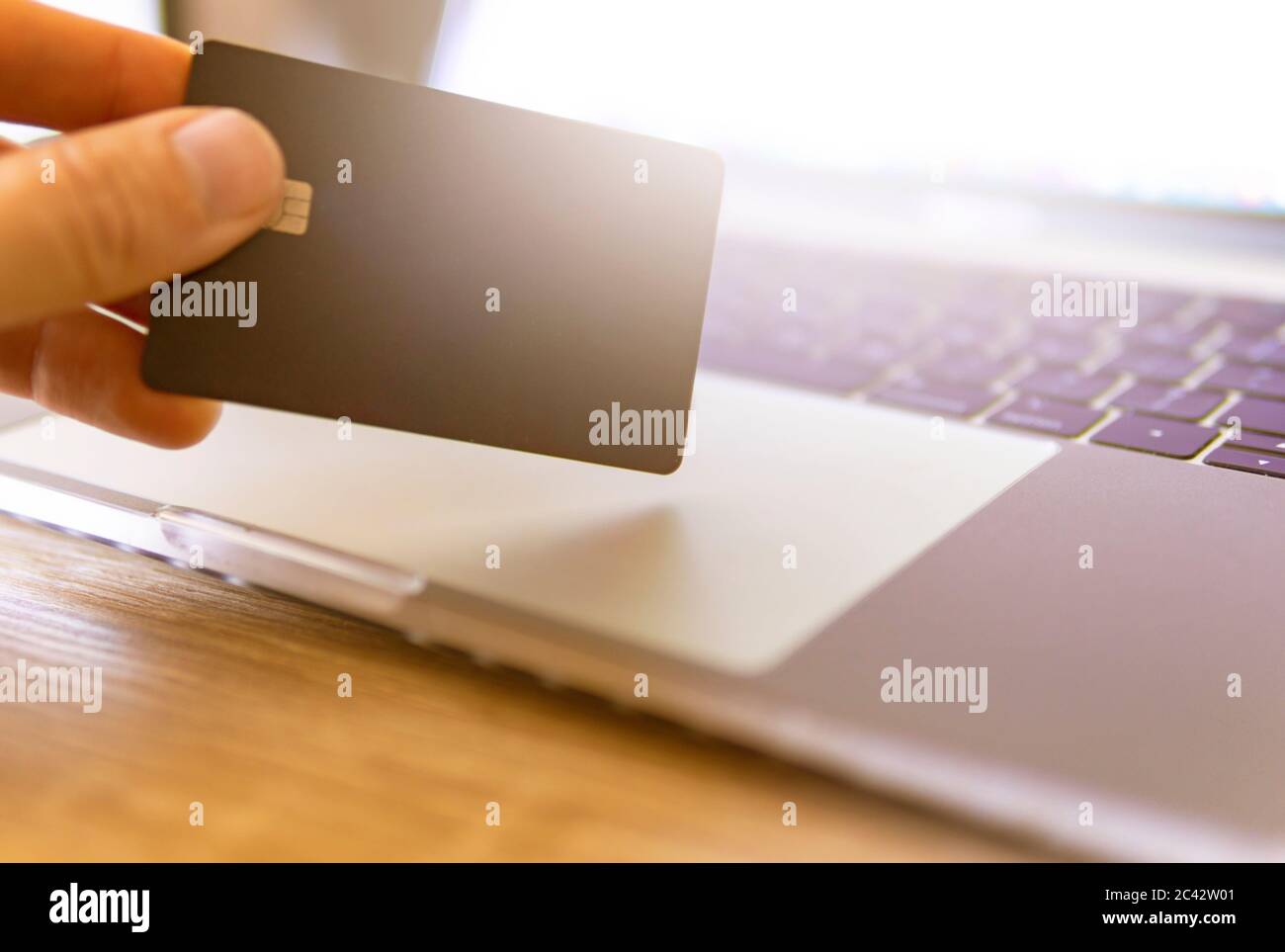 Mano che tiene carta di credito con il laptop per fare l'e-commerce Acquisto Foto Stock