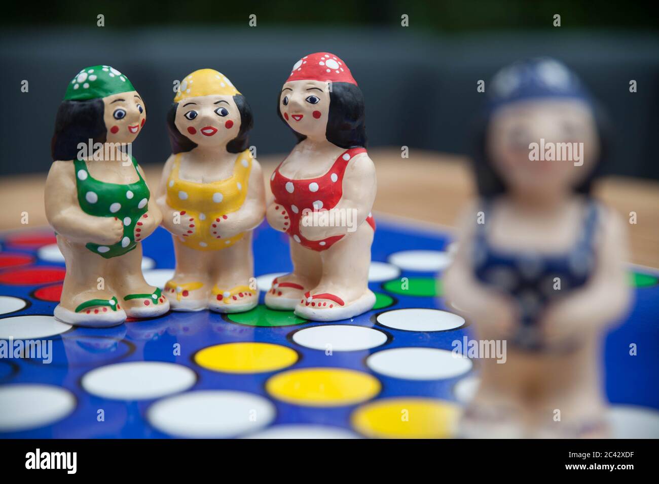 Amicizia e pettegolezzi: Una scena con quattro figurine che mostrano tre amici femminili che parlano o sussurrano in modo confidenziale, mentre un'altra donna guarda sopra. Foto Stock