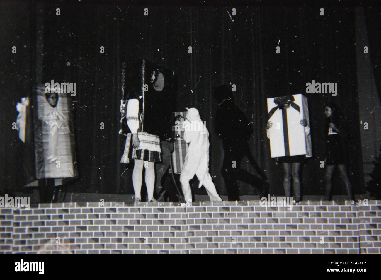 Fine anni '70 vintage contatto stampa in bianco e nero fotografia di studenti elementari che eseguono un gioco sul palco. Foto Stock