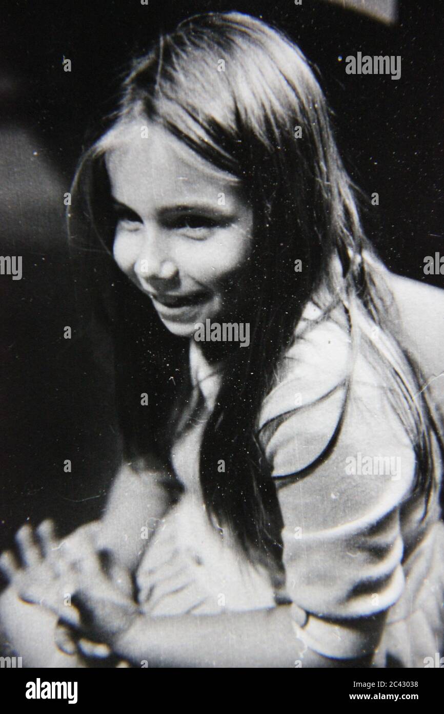 Fine anni '70 vintage in bianco e nero stile di vita fotografia di una giovane ragazza che si appende a casa e divertirsi. Foto Stock