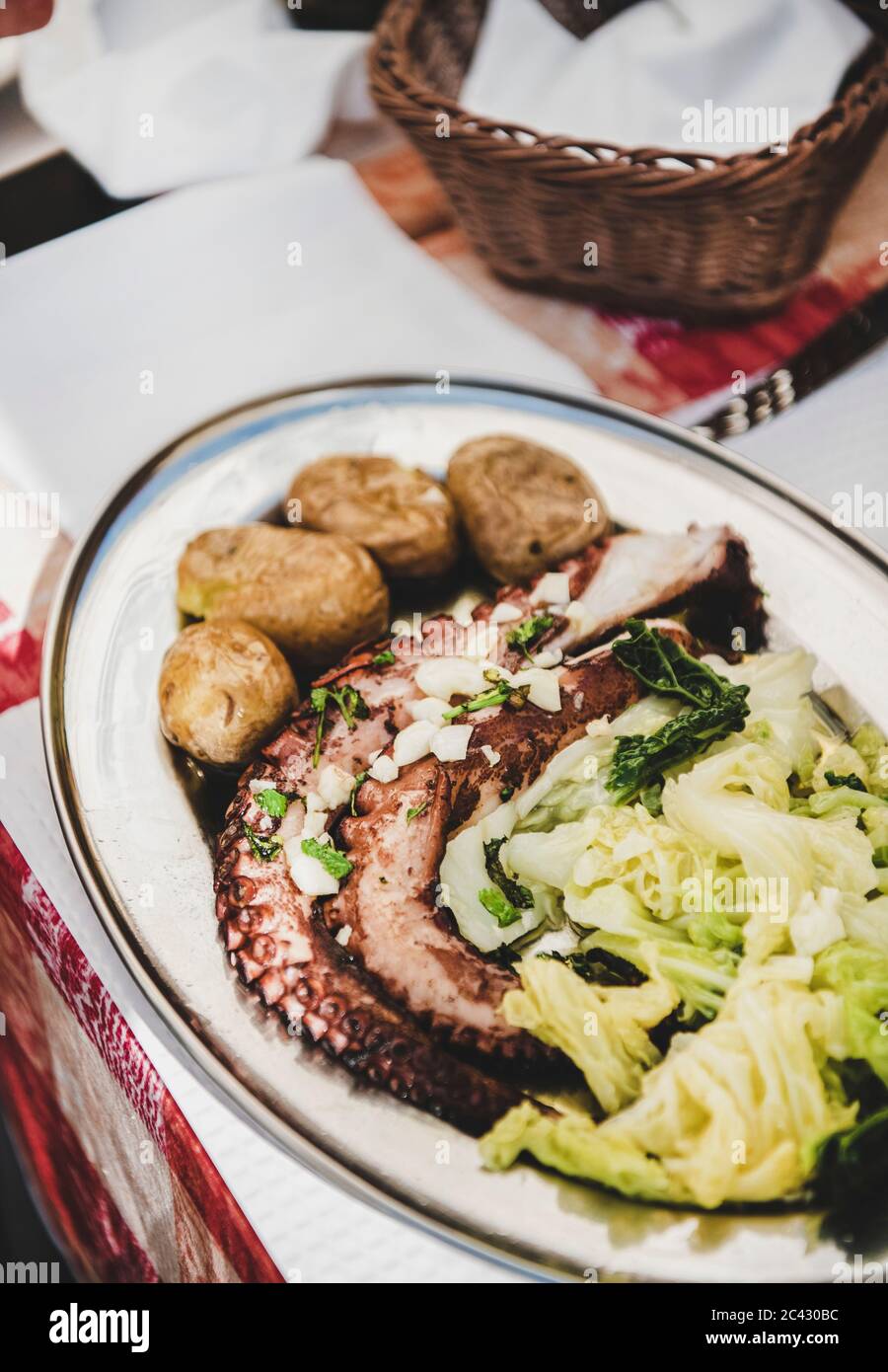 Pranzo o cena a base di pesce tradizionale nel ristorante locale di Lisbona. Polpo alla griglia con patate bollite e cavolo servito sul tavolo, fuoco selettivo, clo Foto Stock