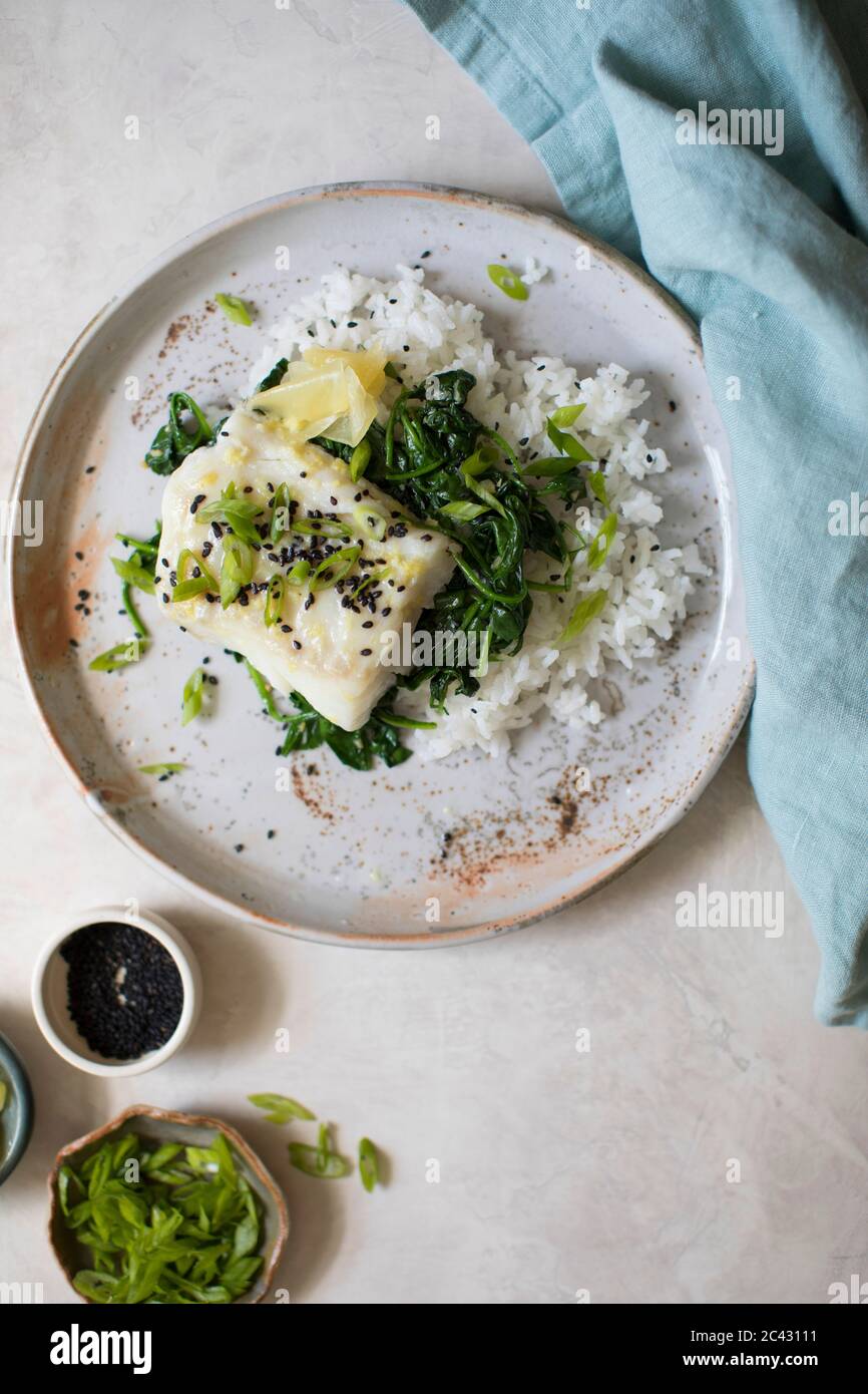 Filetto di pesce al forno con spinaci saltati e fagioli verdi su un letto di riso. Foto Stock