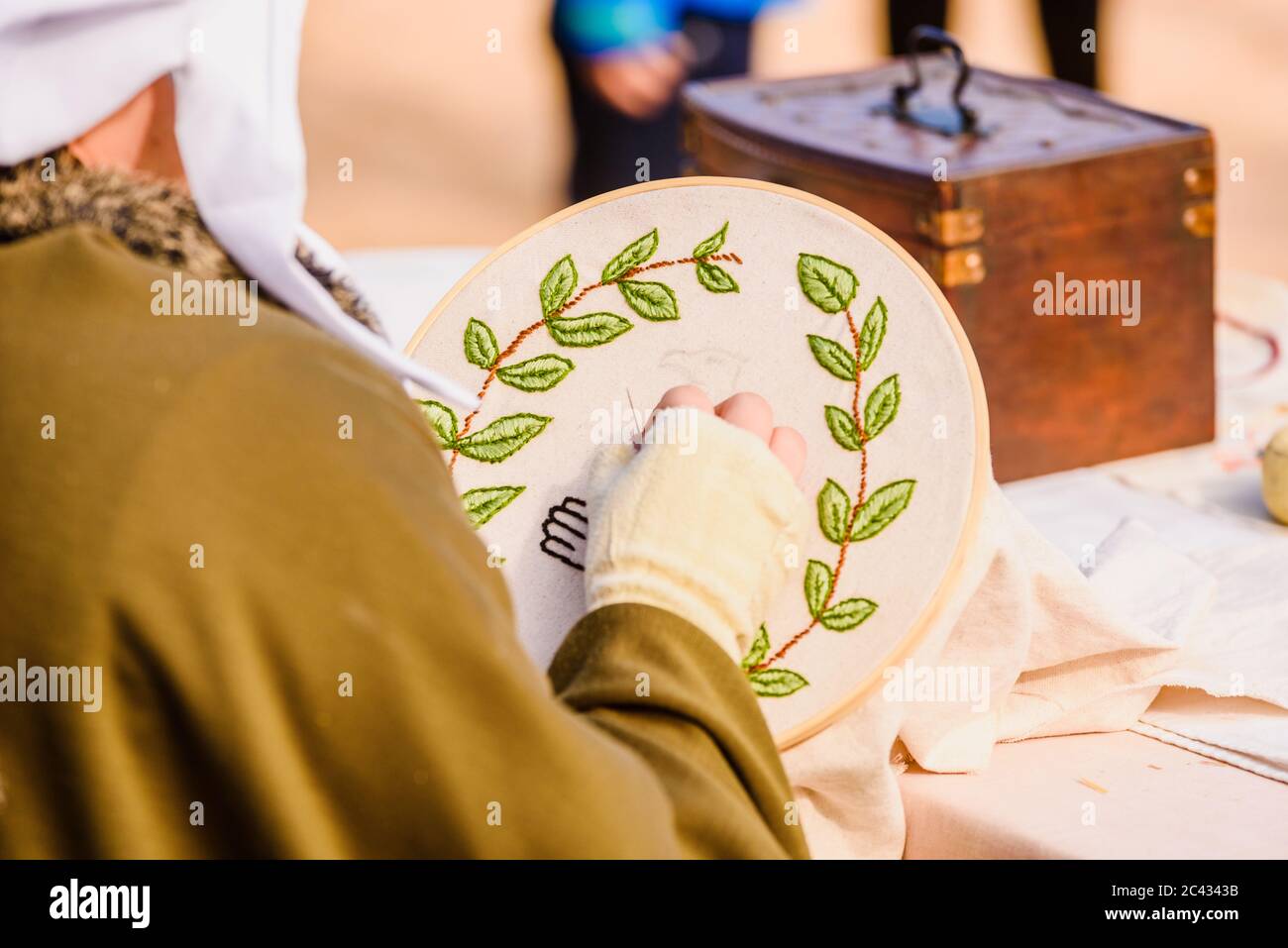 Giovane donna sarta cucito un semplice disegno, dissimulata come medieval in un artigianato tradizionale per bambini. esposizione Foto Stock