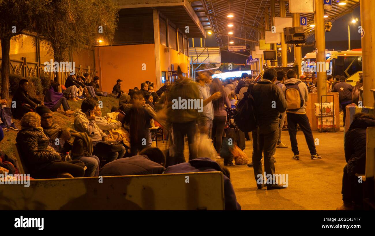 Quito, Pichincha / Ecuador - Marzo 29 2019: Turisti in attesa di salire a bordo dell'autobus al terminal degli autobus di Carcelen durante la notte Foto Stock