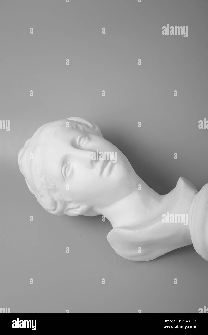 Ragazza Venere testa gesso ritratto su sfondo grigio Foto Stock