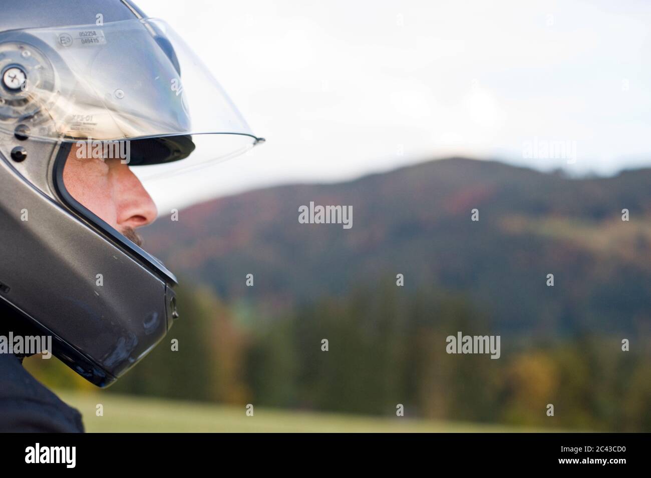 Uomo con casco per moto, Bavarese Alpine Foreland, Baviera, Germania Foto Stock
