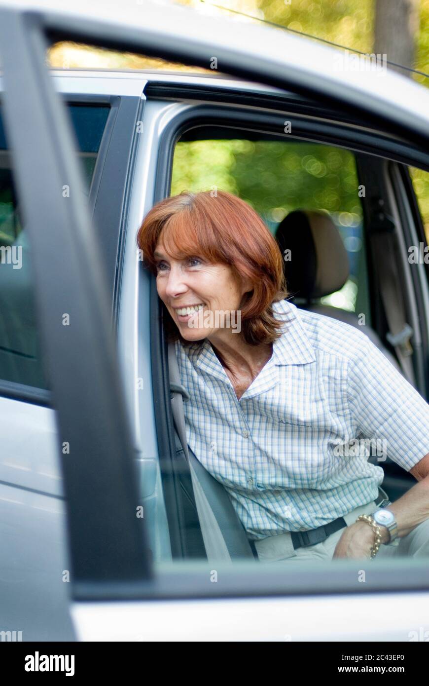Donna matura sorridente su un'auto, Monaco, Baviera, Germania Foto Stock