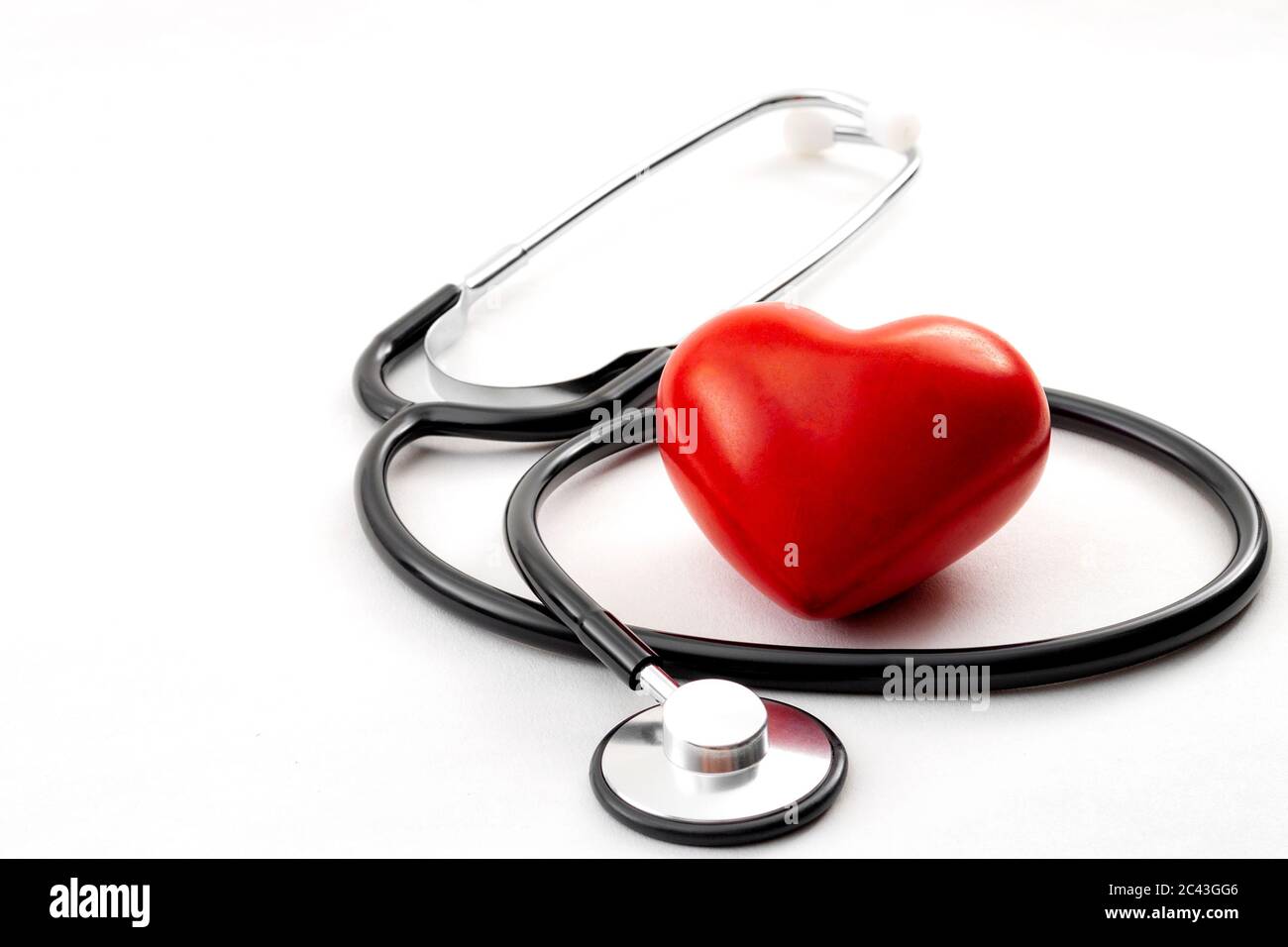 Controllo annuale della salute, diagnosi di malattie, medicina sanitaria e cardiologia concetto con un cuore rosso e uno stetoscopio isolato su un ospedale bianco Foto Stock