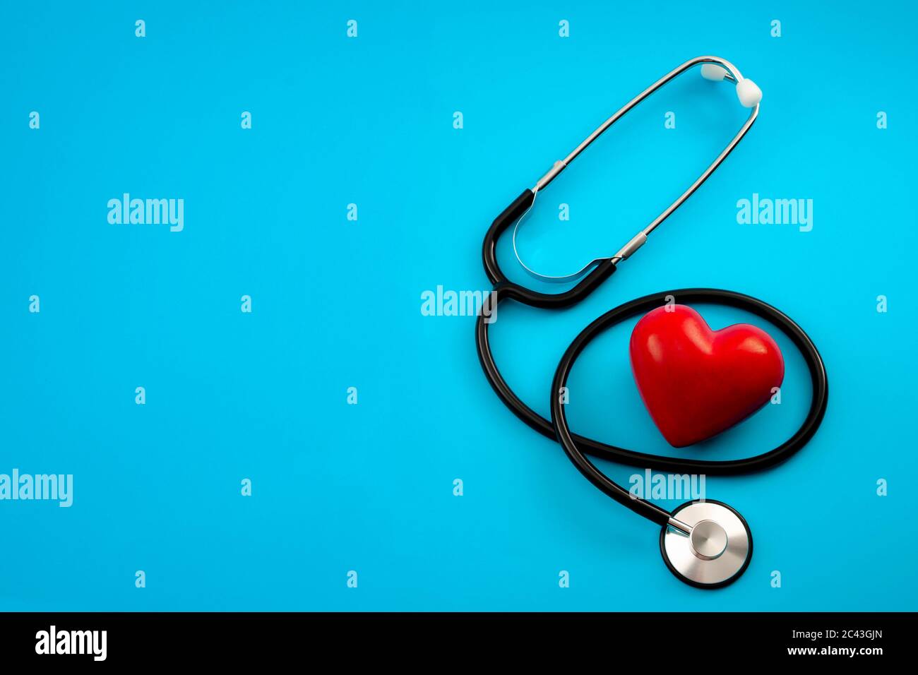 Controllo annuale della salute, diagnosi di malattia, medicina sanitaria e cardiologia concetto con un cuore rosso e uno stetoscopio isolato su un ospedale blu b Foto Stock