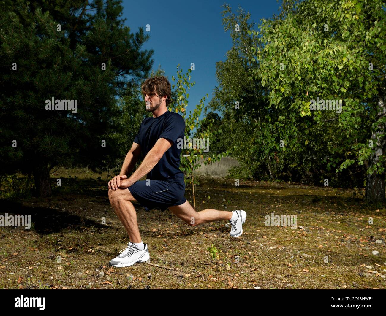 Jogger si estende in una zona rurale, Monaco, Baviera, Germania Foto Stock