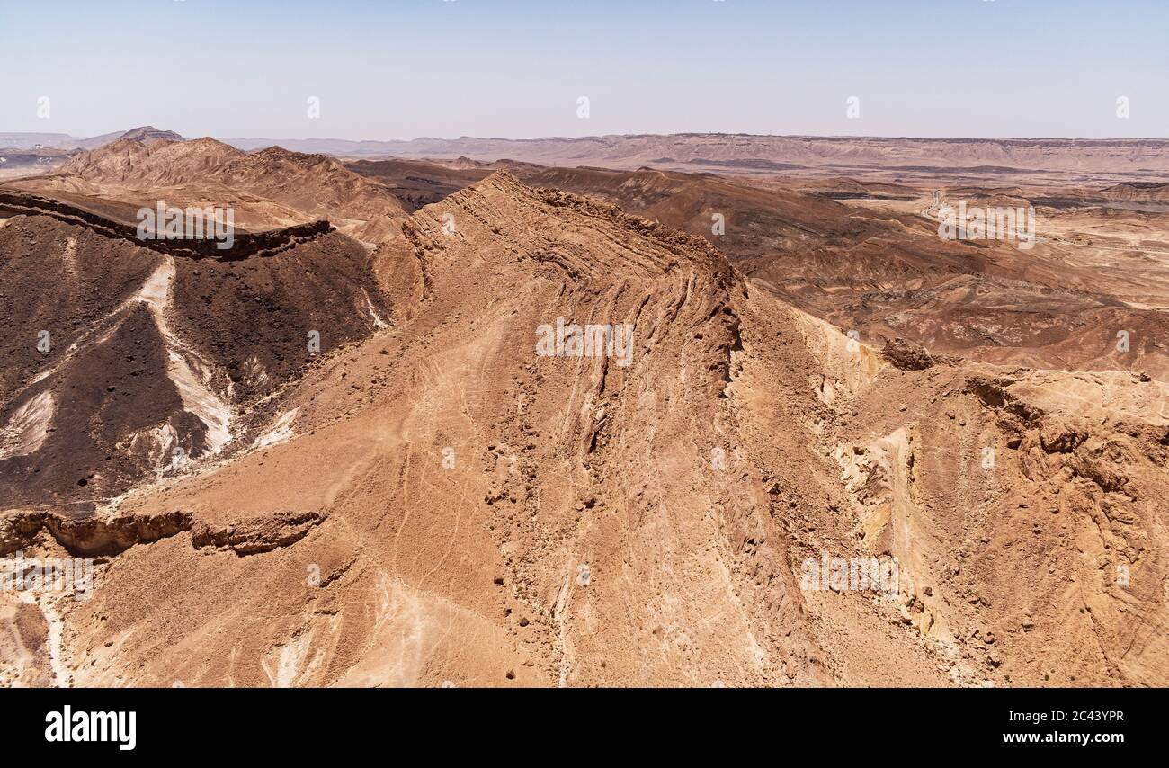 closeup aereo del cratere di makhtesh ramon in israele che mostra una collina di gesso ricoperta di ferte e selce sulla sinistra accanto ad un'antica formazione calcarea Foto Stock