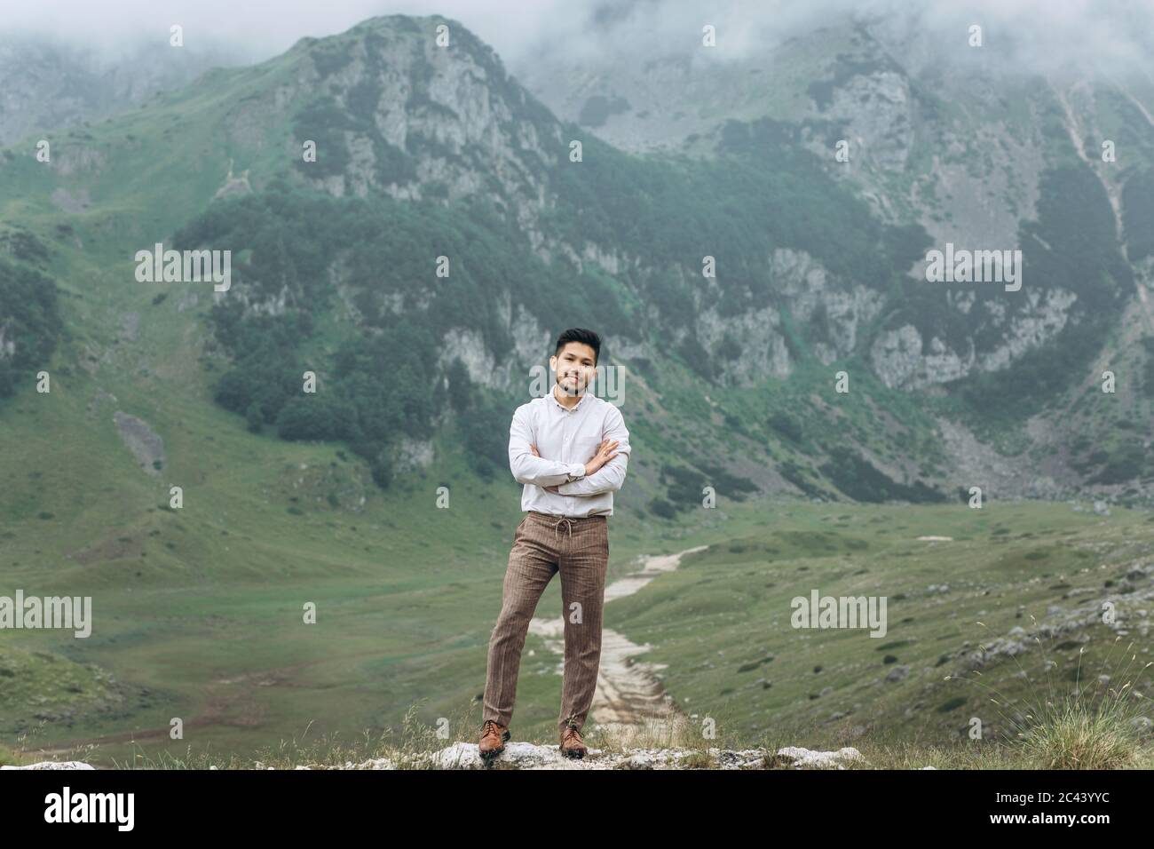 Ritratto di un bel giovane kazako sullo sfondo di montagne. Foto Stock