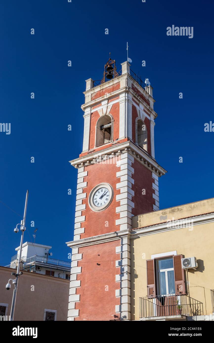 Torre dell'orologio, rossa con mattoni bianchi. L'edificio risale al XIX secolo. Campane sulla parte superiore. Telecamere di sorveglianza. Cerignola, Puglia, Ital Foto Stock