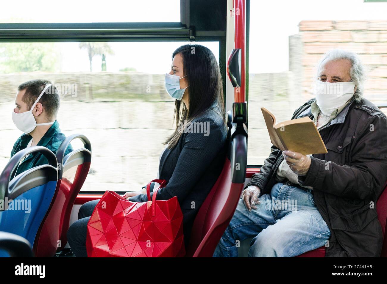 Passeggeri che indossano maschere di protezione in autobus pubblico, Spagna Foto Stock