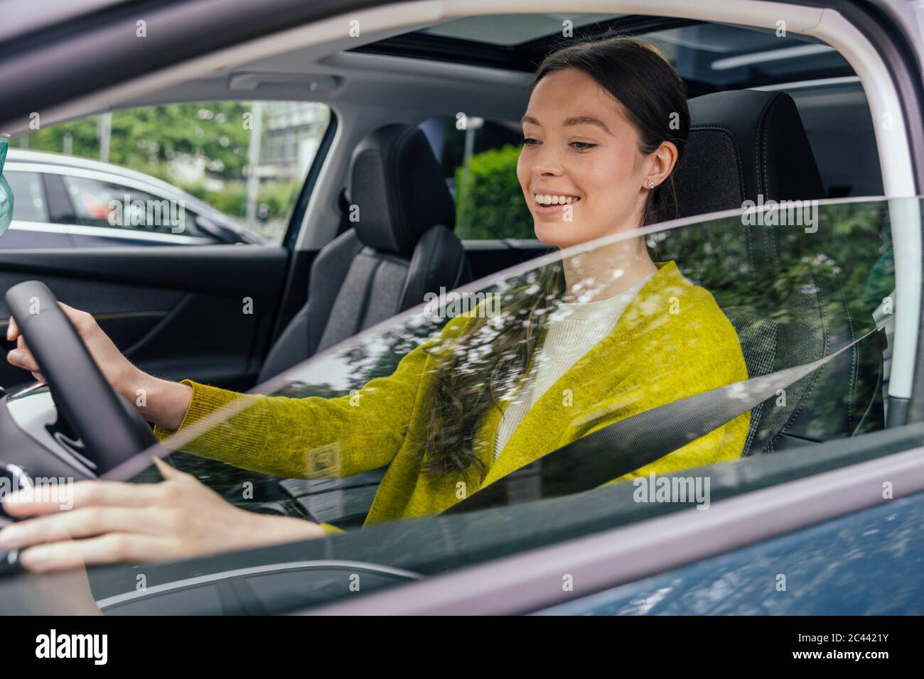 Ritratto di donna sorridente con auto guida Foto Stock