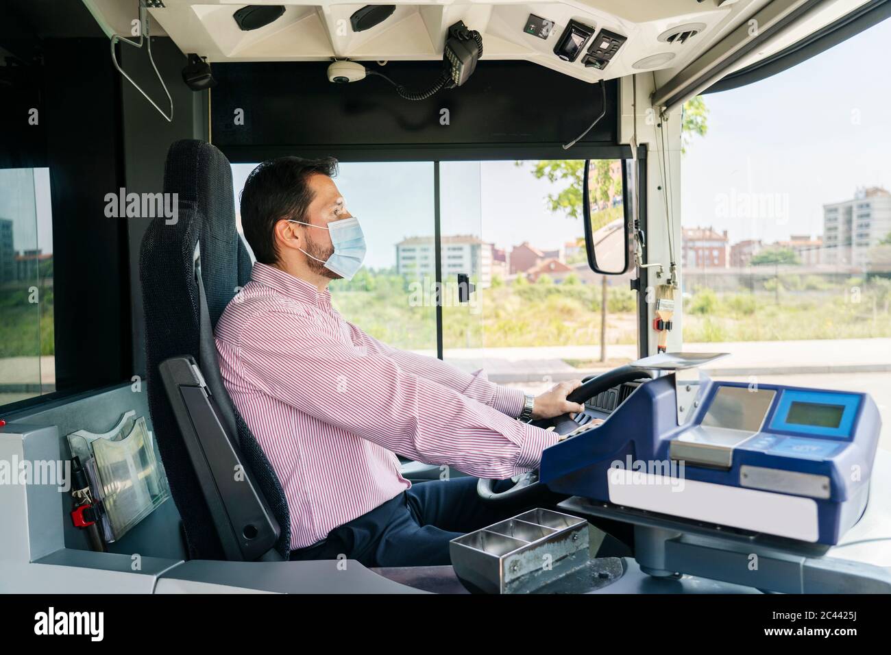 Autista maturo che indossa una maschera protettiva in attesa alla fermata dell'autobus, Spagna Foto Stock