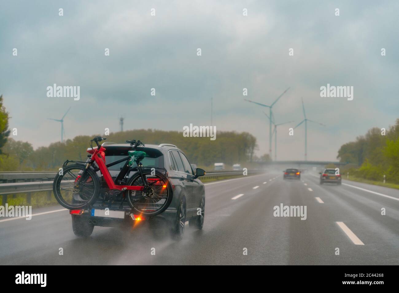 Autostrada durante la pioggia, auto con portabiciclette Foto Stock