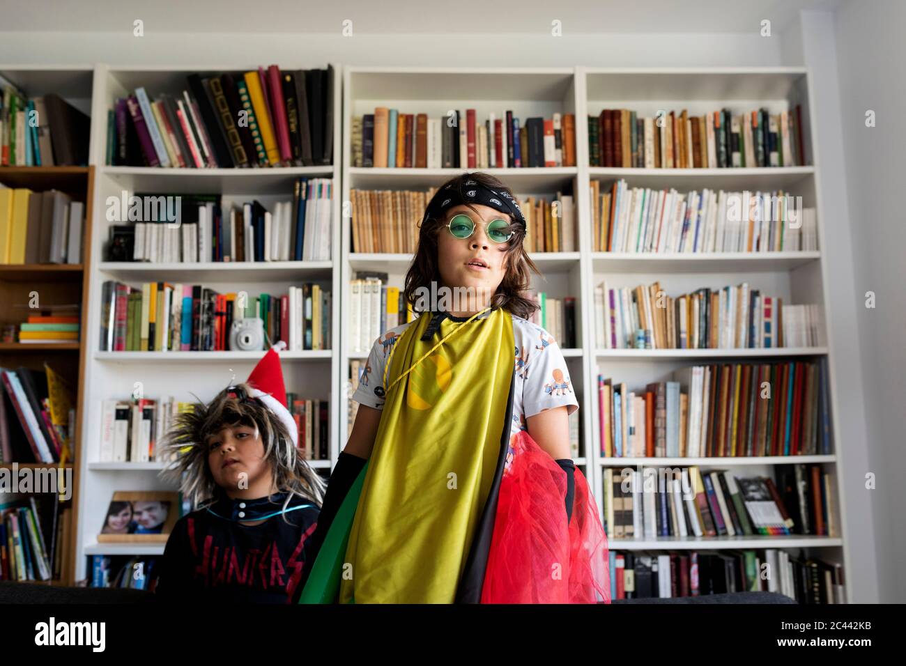 Ritratto di ragazzo vestito da rock star nel salotto con il fratello minore Foto Stock