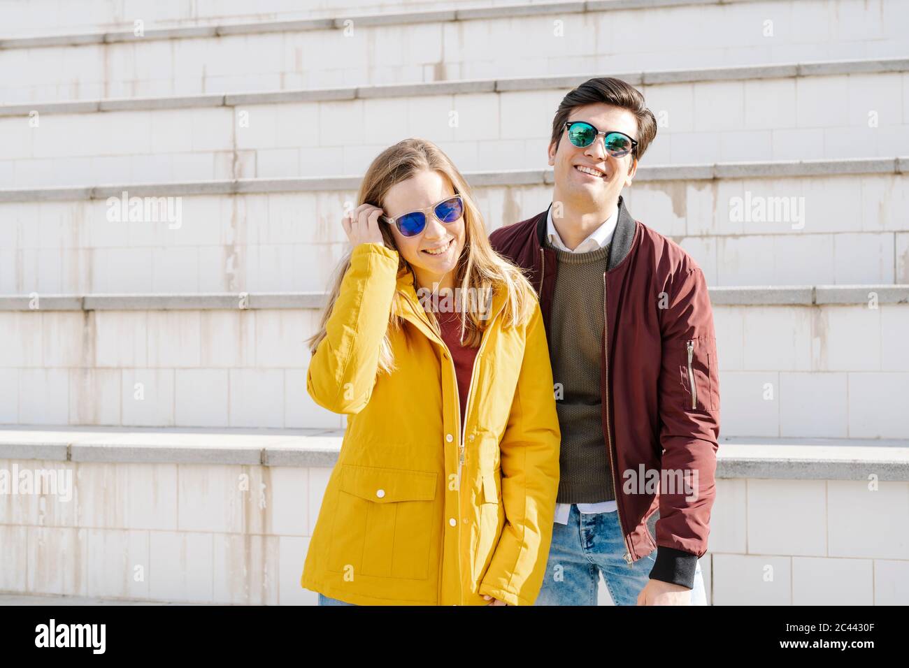 Ritratto di giovane coppia felice in piedi alle scale Foto Stock