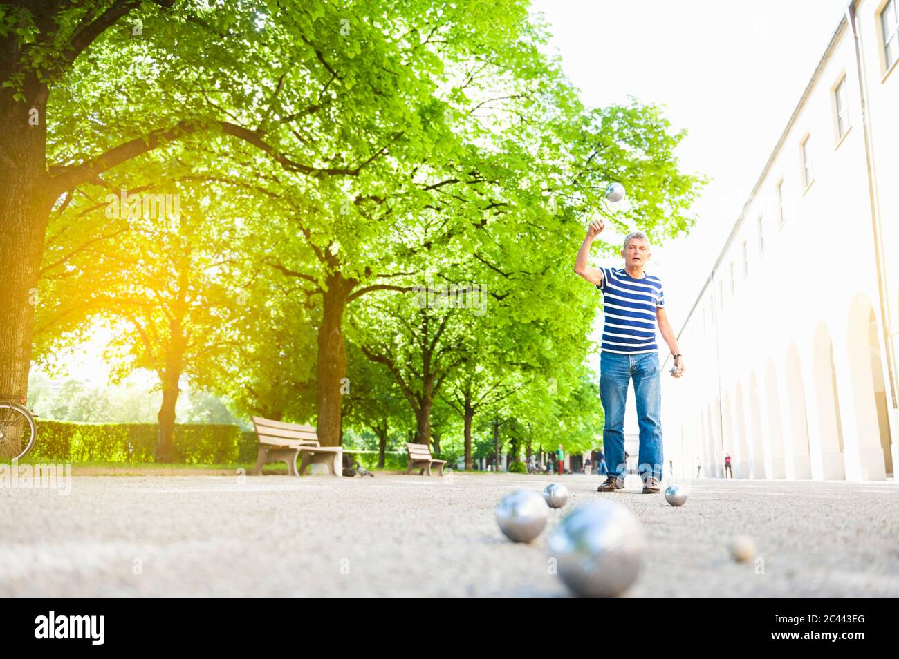 Uomo anziano che lancia palloni Foto Stock