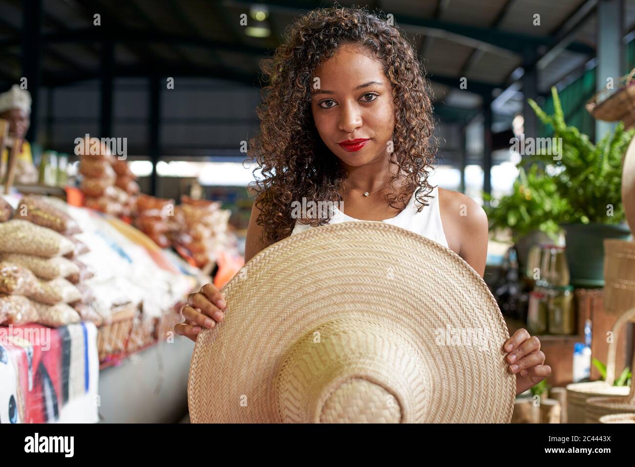 Ritratto di donna con cappello di paglia presso la sala del mercato Foto Stock