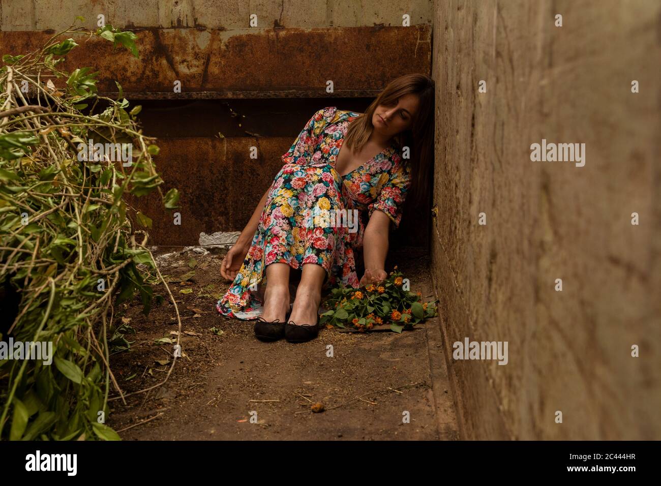 Triste donna sola seduta in contenitore Foto Stock