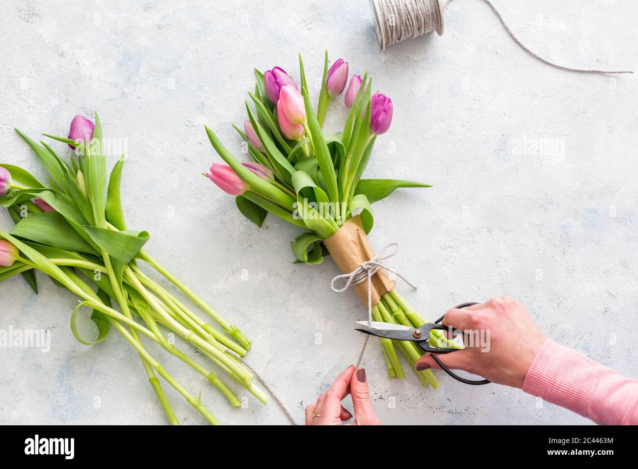Mani di donna che preparano bouquet di tulipani porpora in fiore Foto Stock