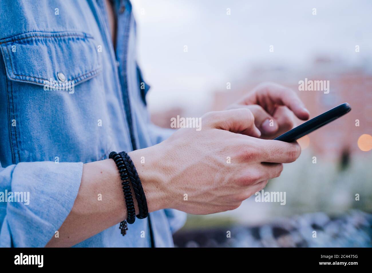 Mano dell'uomo che tiene lo smartphone, primo piano Foto Stock
