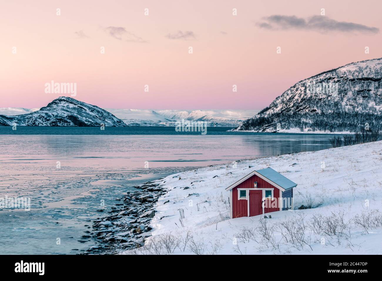 Paesaggio costiero con capanna rossa in inverno, Lebesby, fiordo di Lakse, Norvegia Foto Stock