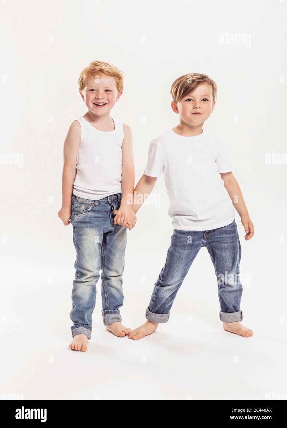 Ritratto di due ragazzini che tengono le mani davanti a sfondo bianco Foto Stock