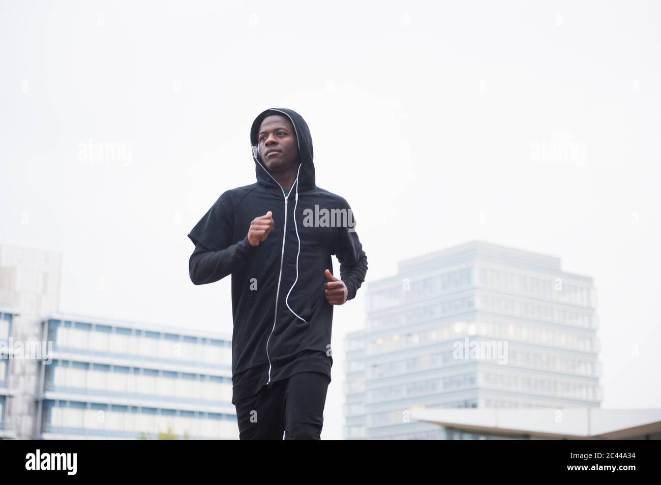 Giovane uomo che fa jogging in città Foto Stock