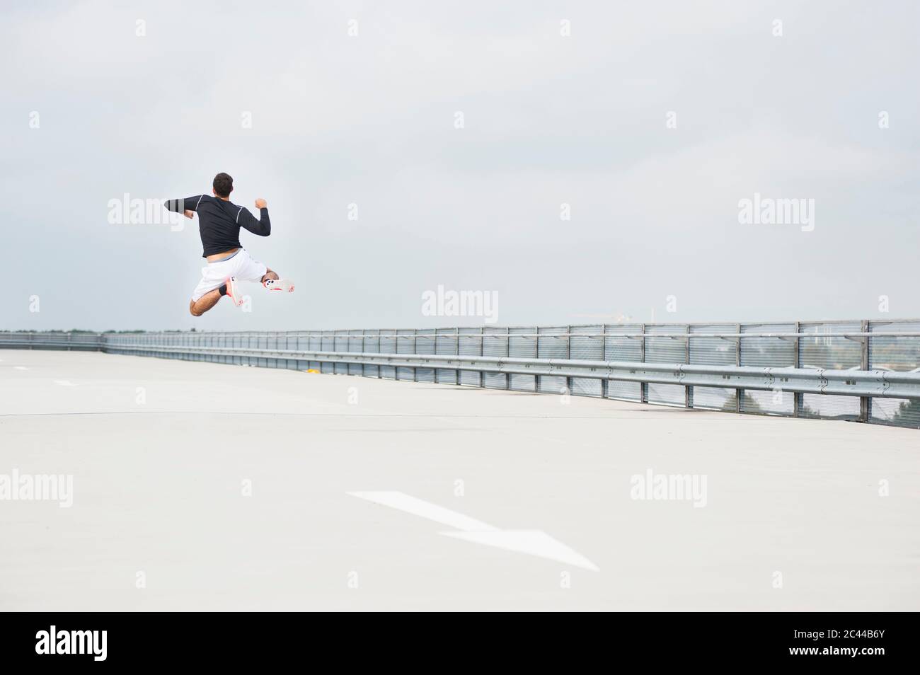 Giovane che salta su un ponte di parcheggio Foto Stock