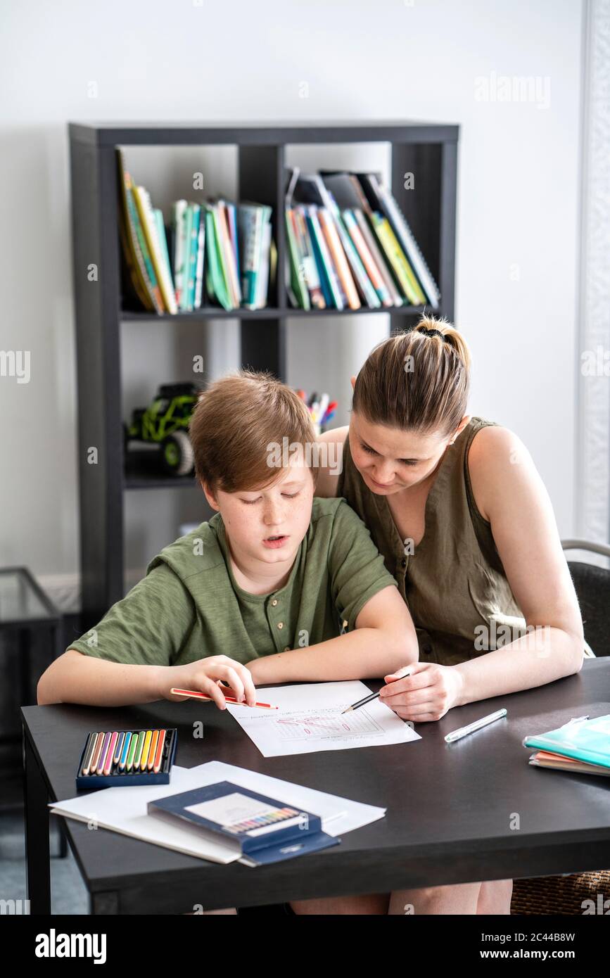 Madre che homeschooling suo figlio a casa Foto Stock