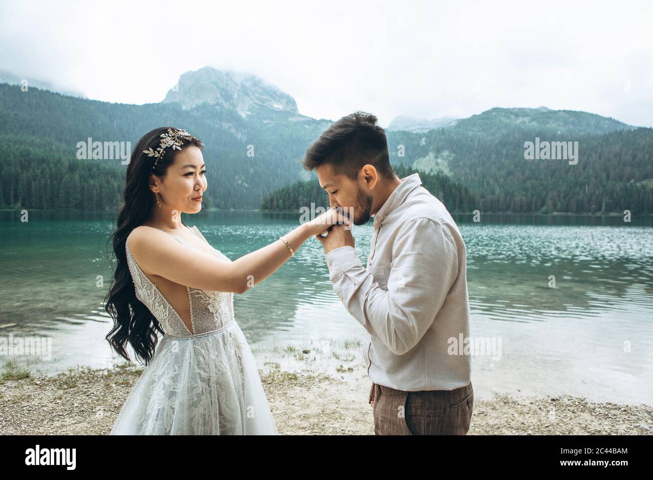 Lo sposo kazako bacia delicatamente le mani della sposa Foto Stock