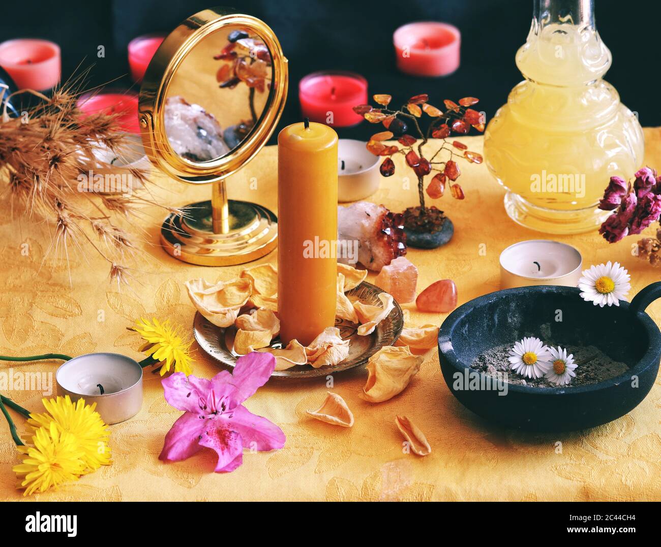 Candela gialla su Litha metà estate Sabbat Solstice celebrazione altare strega riempito di fiori, petali di rosa, dandelioni, cristalli, specchio d'oro Foto Stock