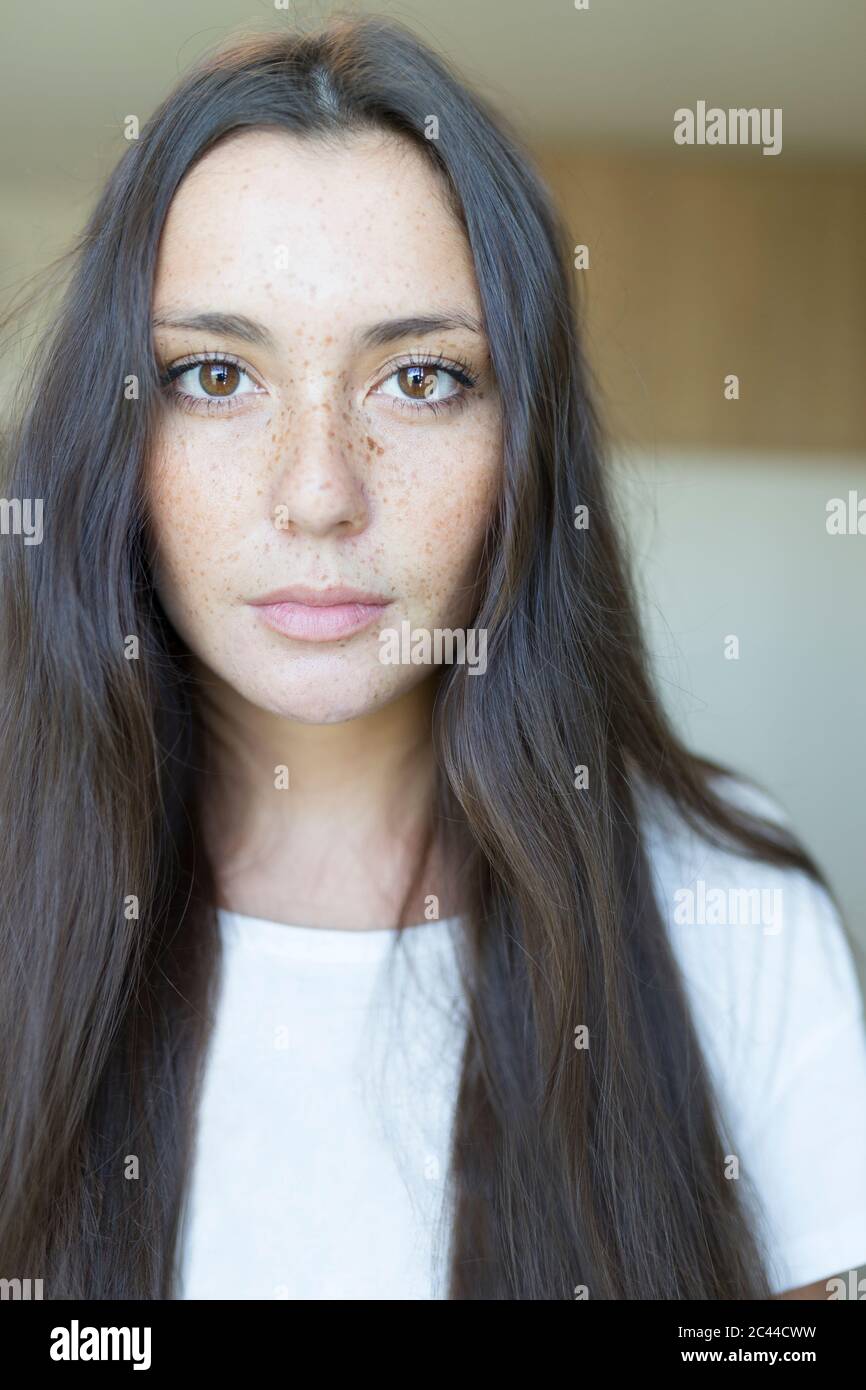 Primo piano ritratto di bella giovane donna con lunghi capelli marroni a casa Foto Stock