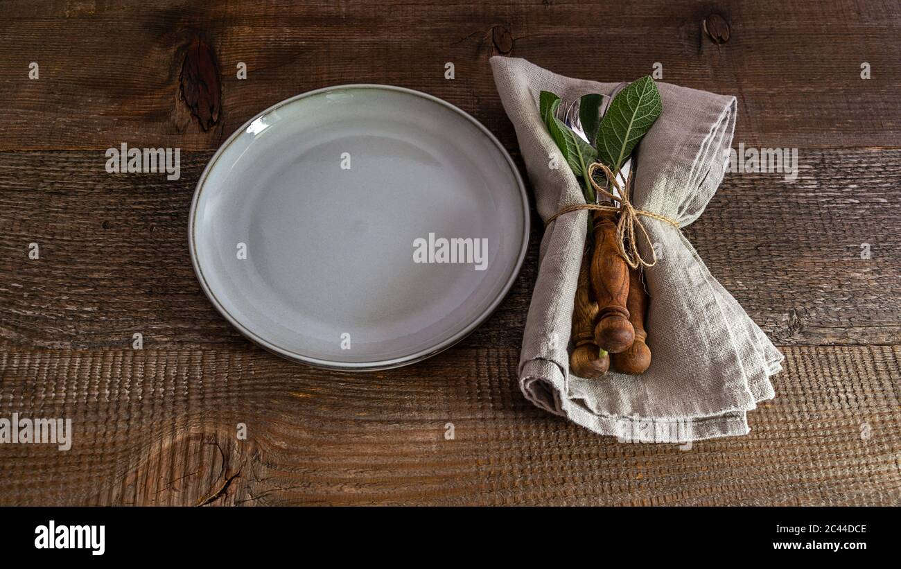 Set di coltelli, cucchiaio, forchetta con tovagliolo di lino sul piatto. Foto Stock