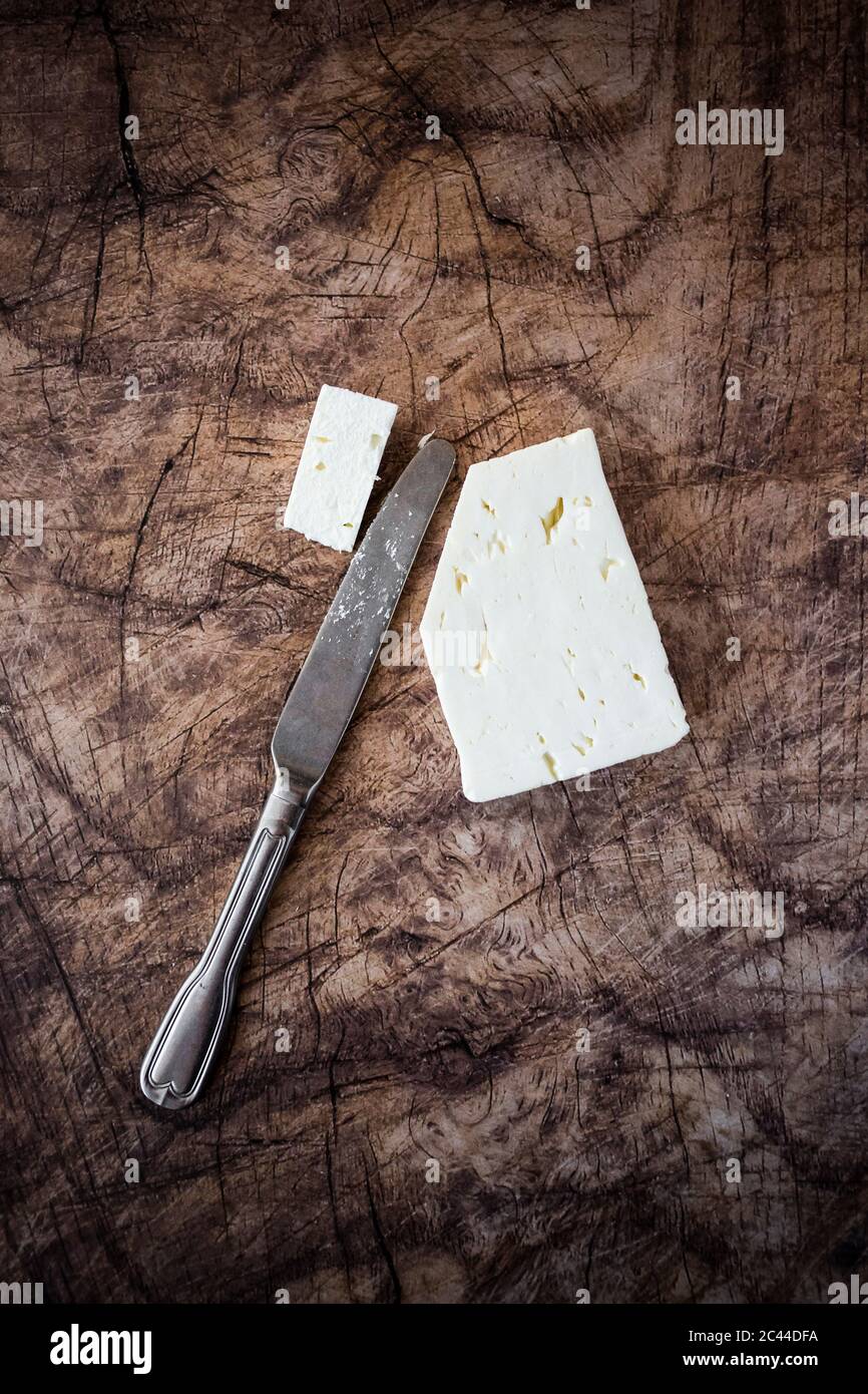 Formaggio feta e coltello da tavola su superficie di legno Foto Stock