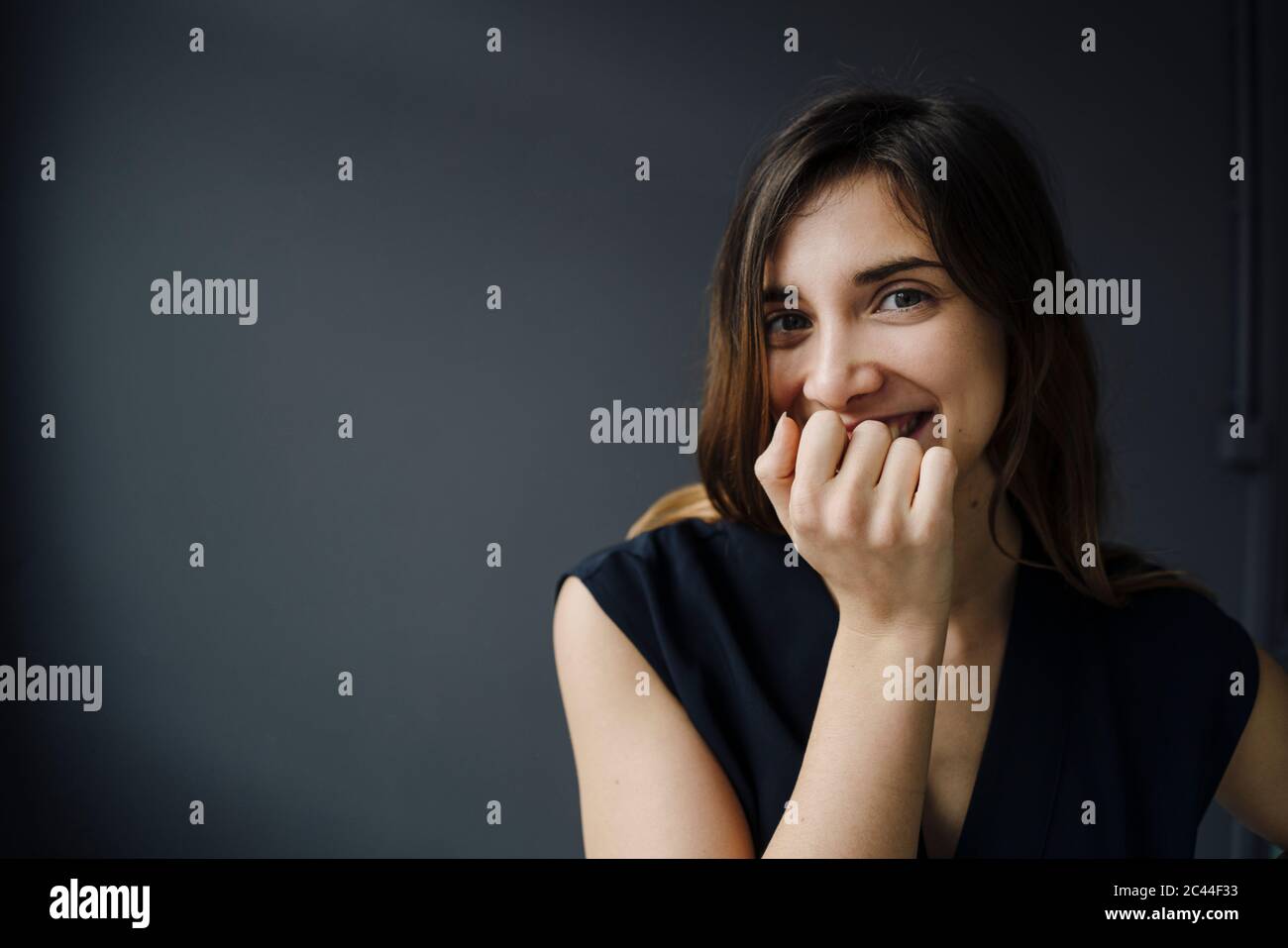 Ritratto di giovane donna ridente con bocca di copertura della mano Foto Stock