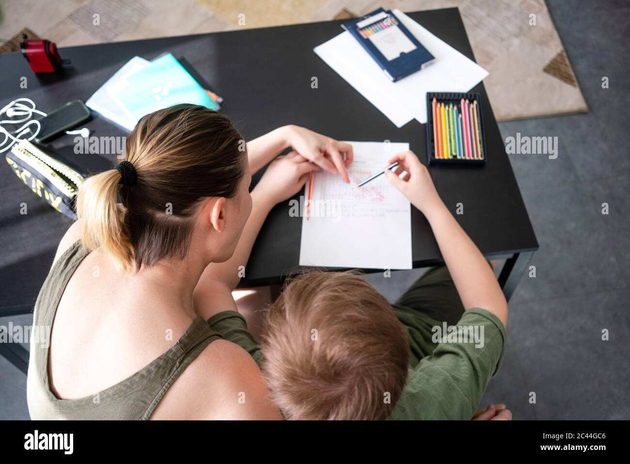 Madre che homeschooling suo figlio a casa Foto Stock